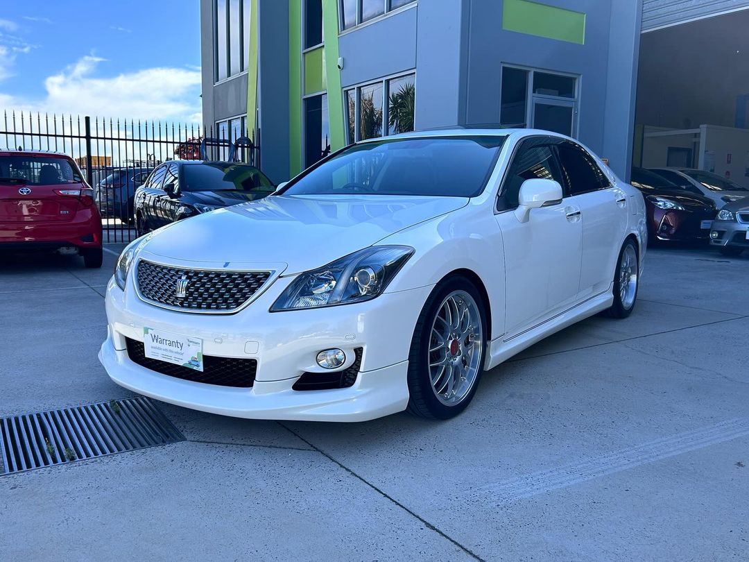 A white Toyota Avalon parked in front of a building.