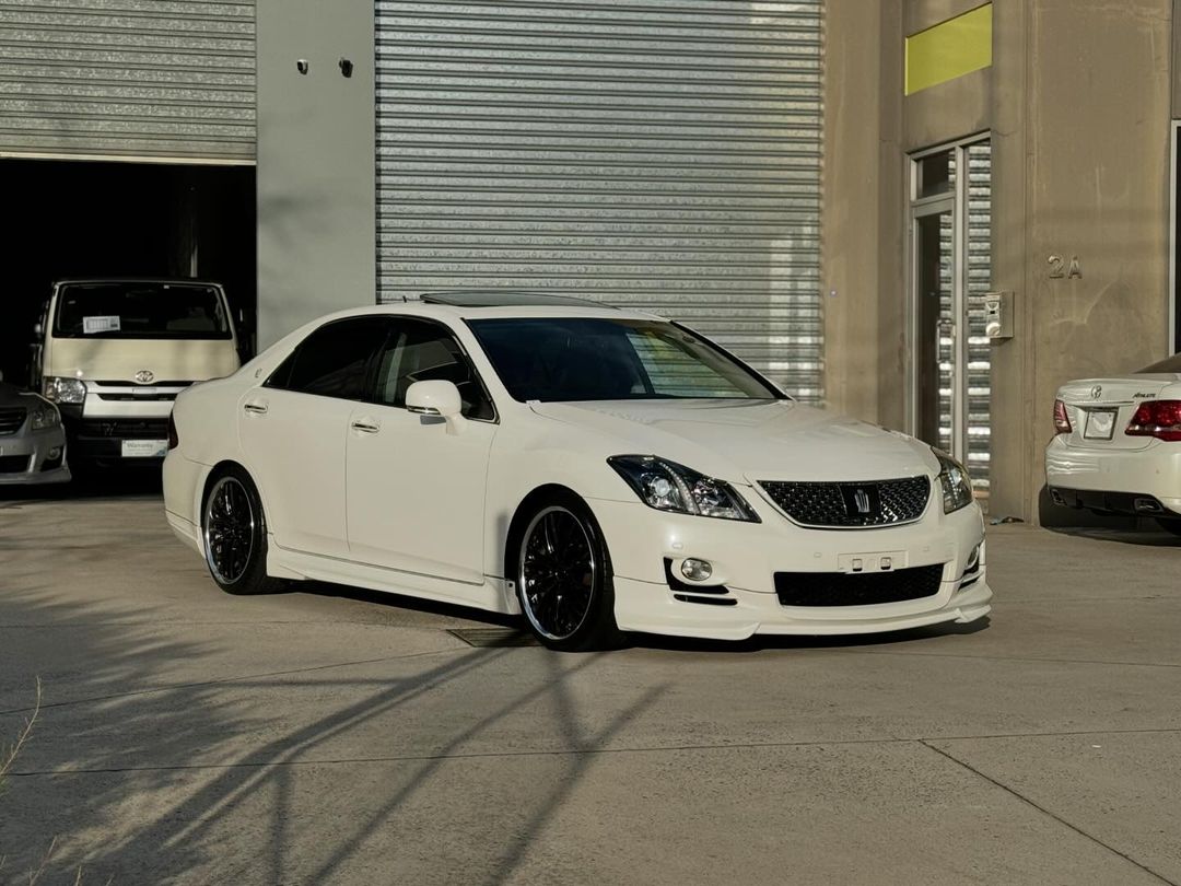 A white car parked in front of a garage.