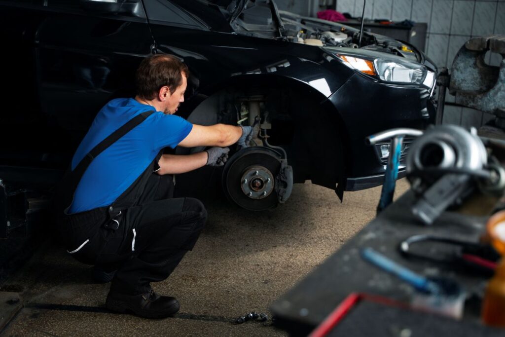 A man fixing a car in a garage.